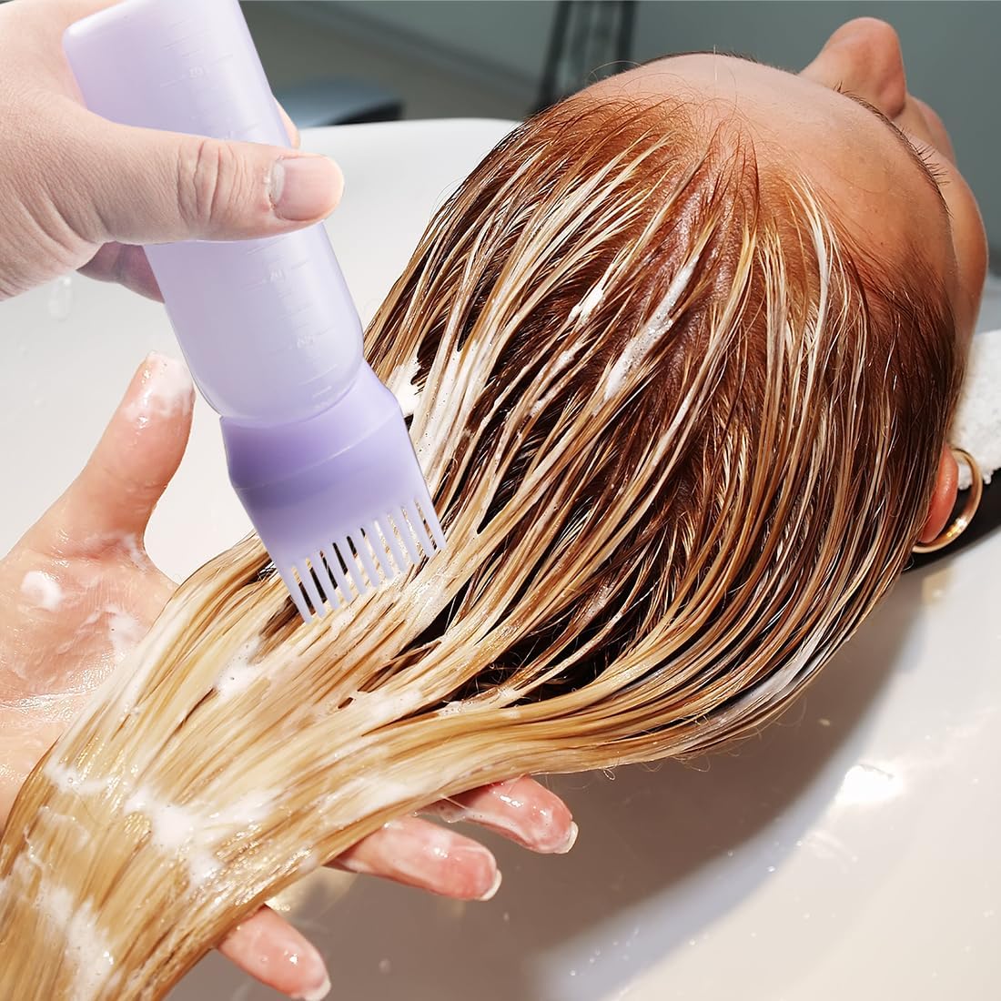 Person washing hair with a purple Magic Collection Root Comb Application Bottle in a sink