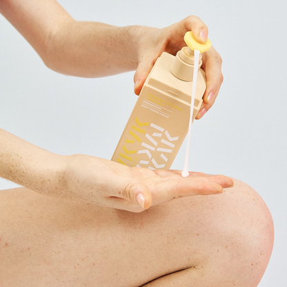 Person applying Makari IYKYK Ceramide Collagen + Peptides Body Toning Cream to their arm against a light gray background