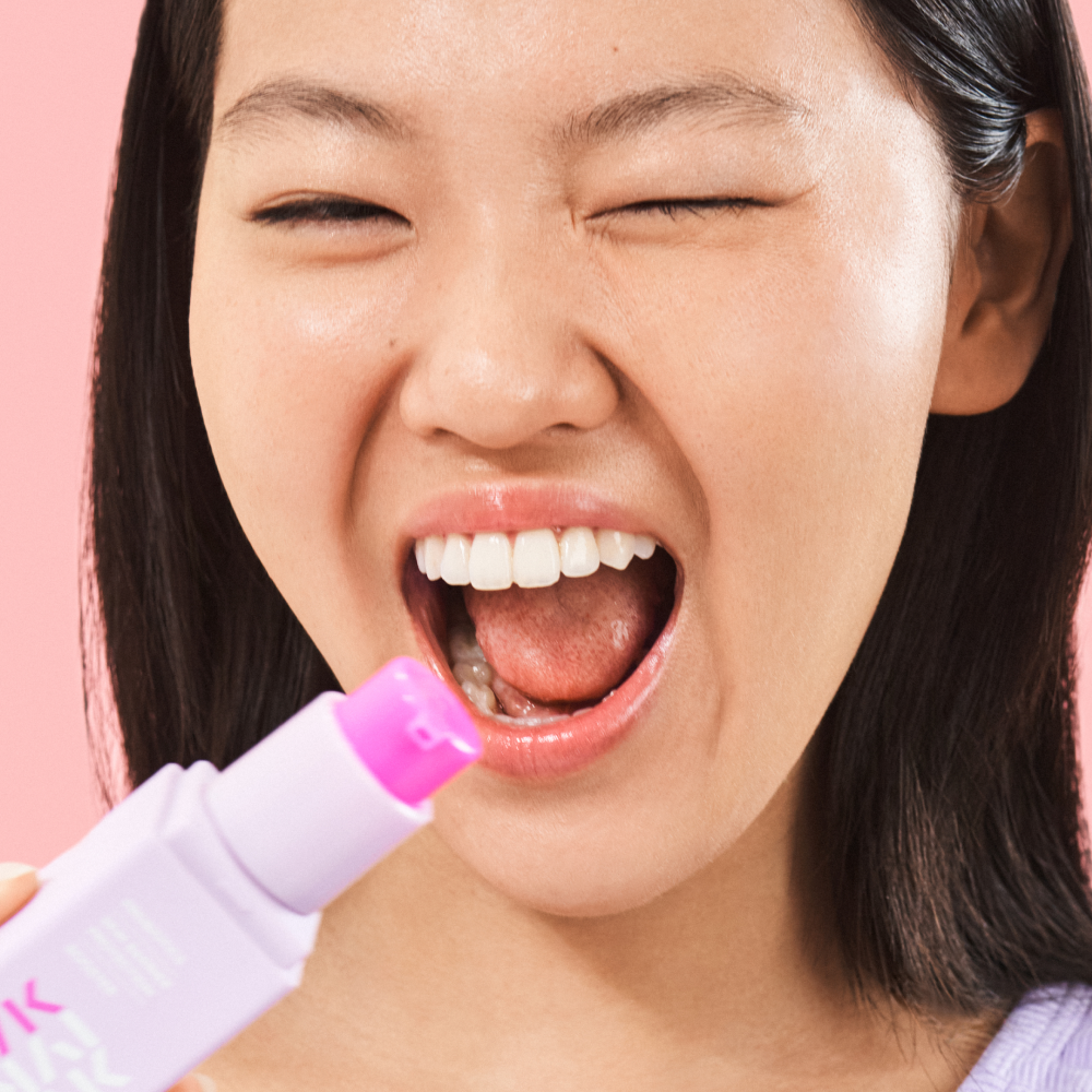 Person holding a pMakari IYKYK Probiotics Skin Barrier Protection Booster against a pink background