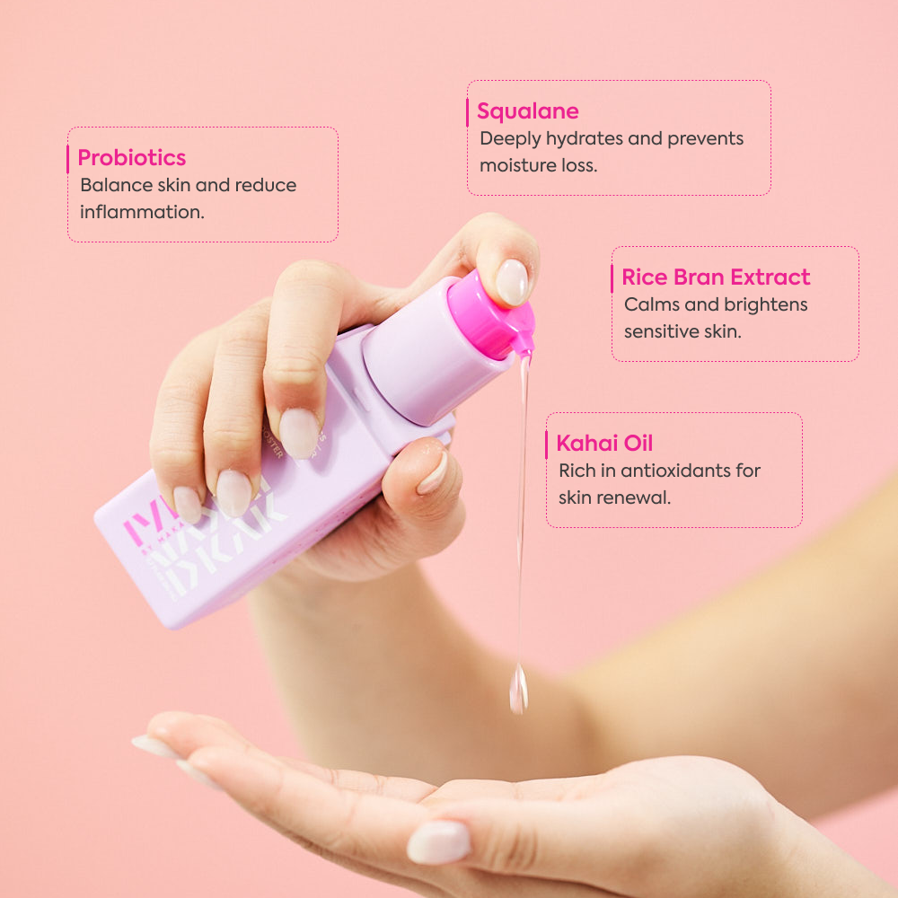 Hand holding a Makari IYKYK Probiotics Skin Barrier Protection Booster  with text about its ingredients on a pink background