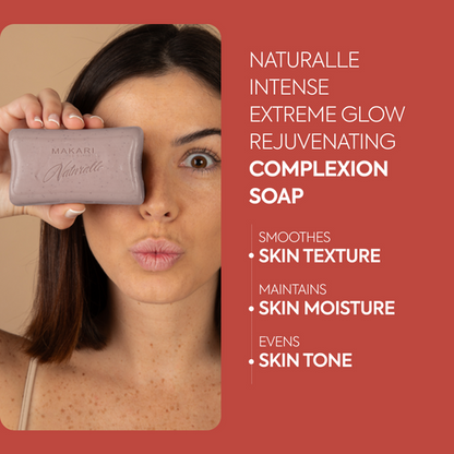Woman holding a bar Makari Naturalle Intense Extreme Glow Rejuvenating Complexion Soap with product details on a red background