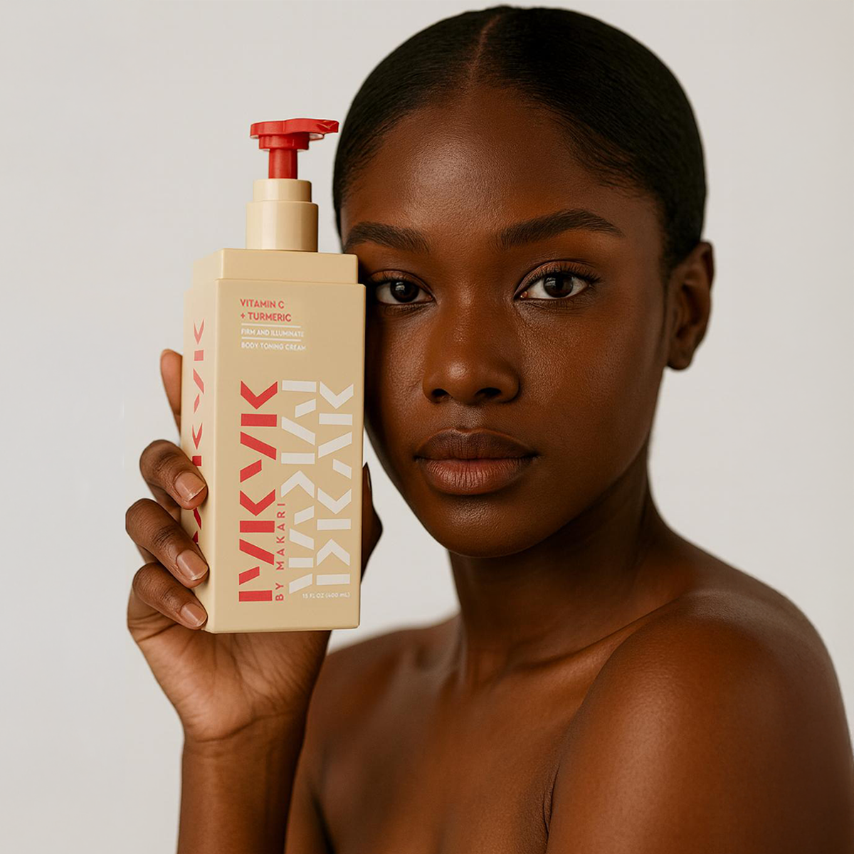 Woman holding Makari IYKYK Vitamin C + Turmeric Body Toning Cream against a neutral background